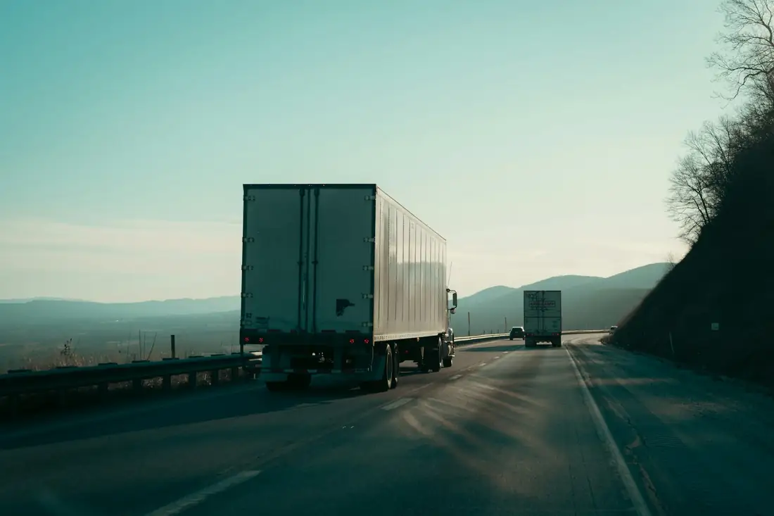 Caminhões de carga em uma rodovia ao entardecer